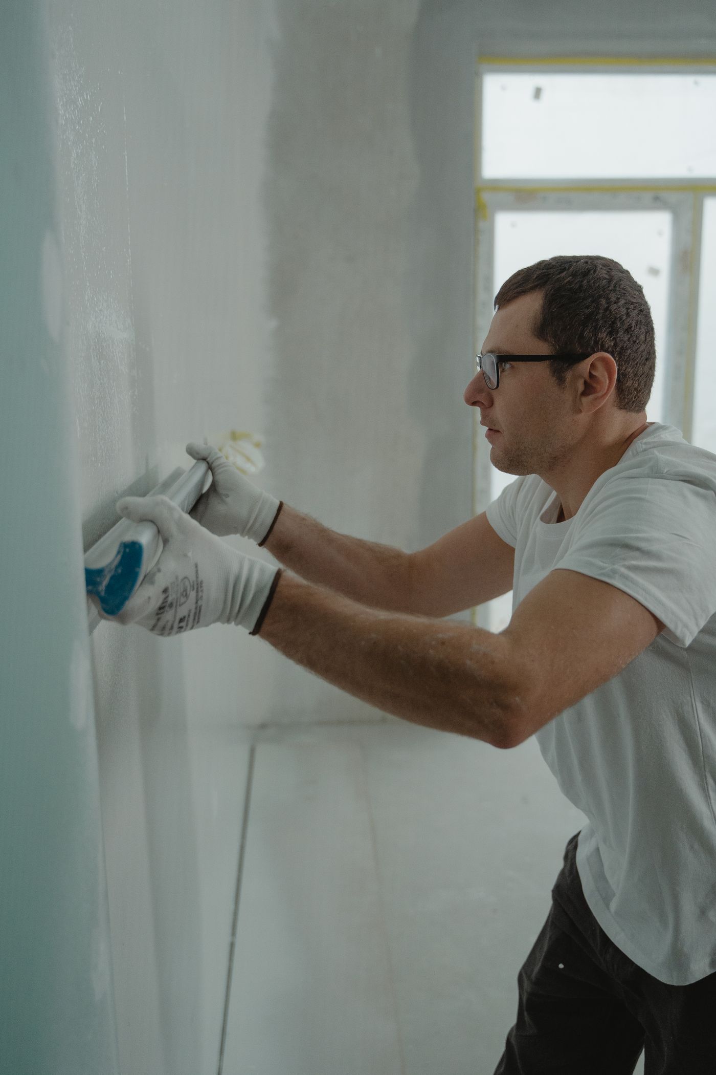 Drywall finisher applying joint compound to a wall seam