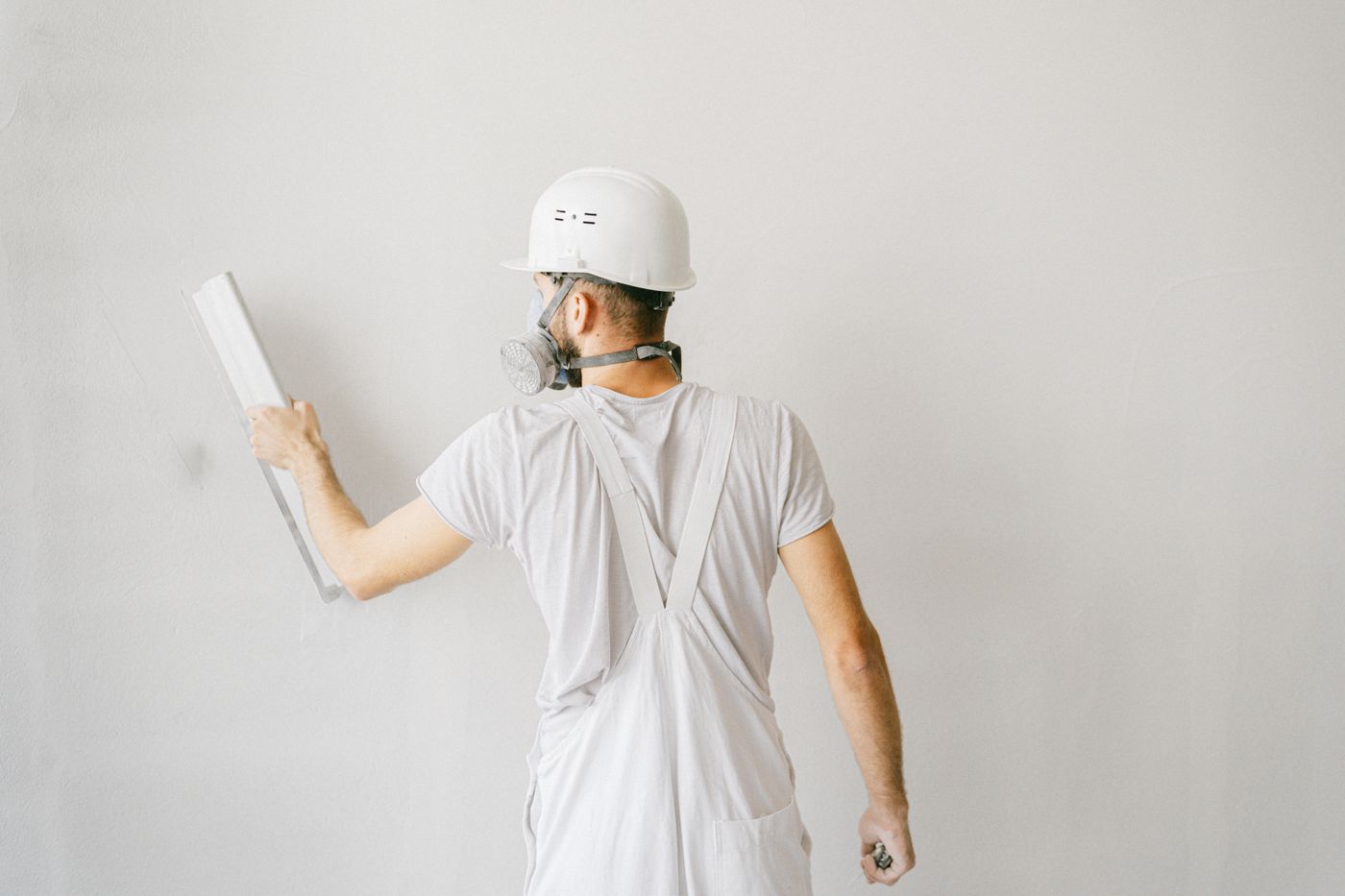 Drywall finisher smoothing a wall with a finishing tool